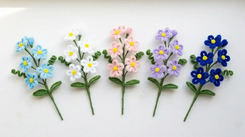 6 pipe cleaner forget-me-not spray variations — classic blue, white, pink, lavender, deep blue and mixed meadow colors on white background